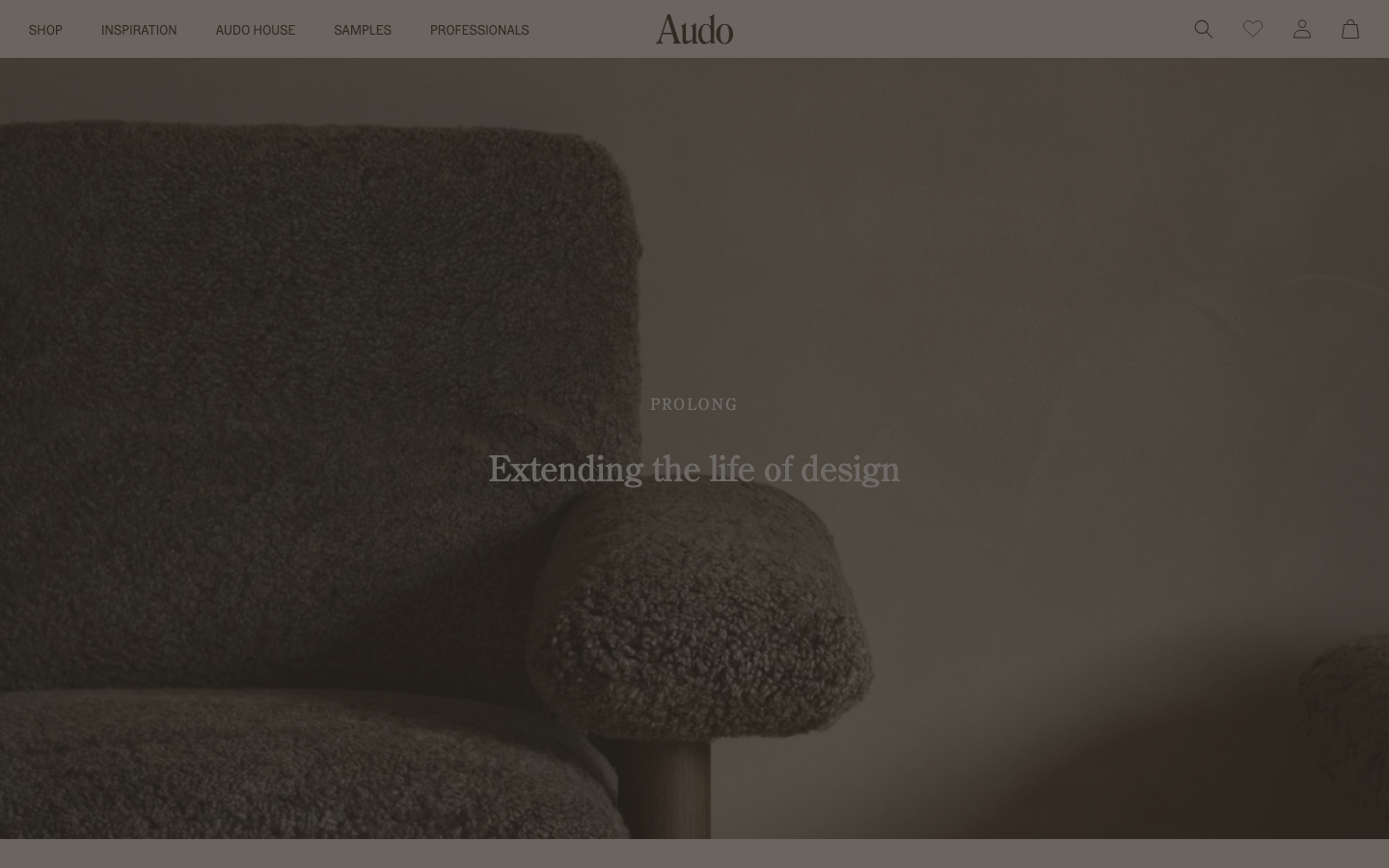 The page uses a full-bleed image to establish a mood, with minimal text overlay. The color palette is muted and earthy, creating a sense of understated elegance. Typography is clean and legible, prioritizing visual impact over extensive information. · minimalist portfolio, soft branding, editorial website, muted color palette, fullbleed image, calm aesthetic, studio website, clean typography, decade retrospective, audocph