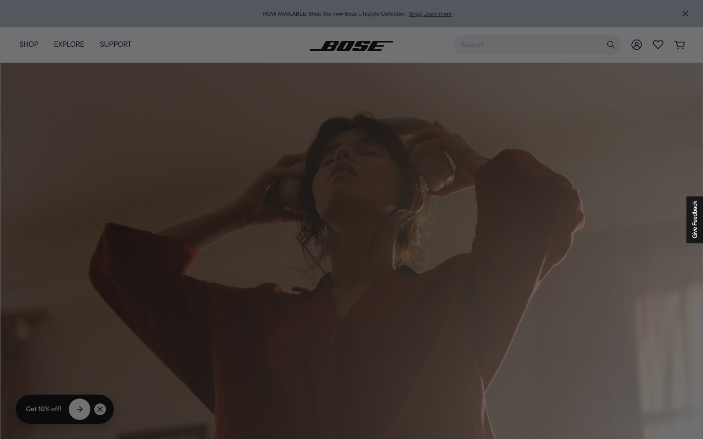 The page uses a full-screen image and minimal text to establish a sophisticated, tech-forward mood. The dark background and subtle purple lighting emphasize the product's sleek design. · audio product, smart speaker, home audio, tech website, minimalist design, dark theme, bose product page, multiroom audio