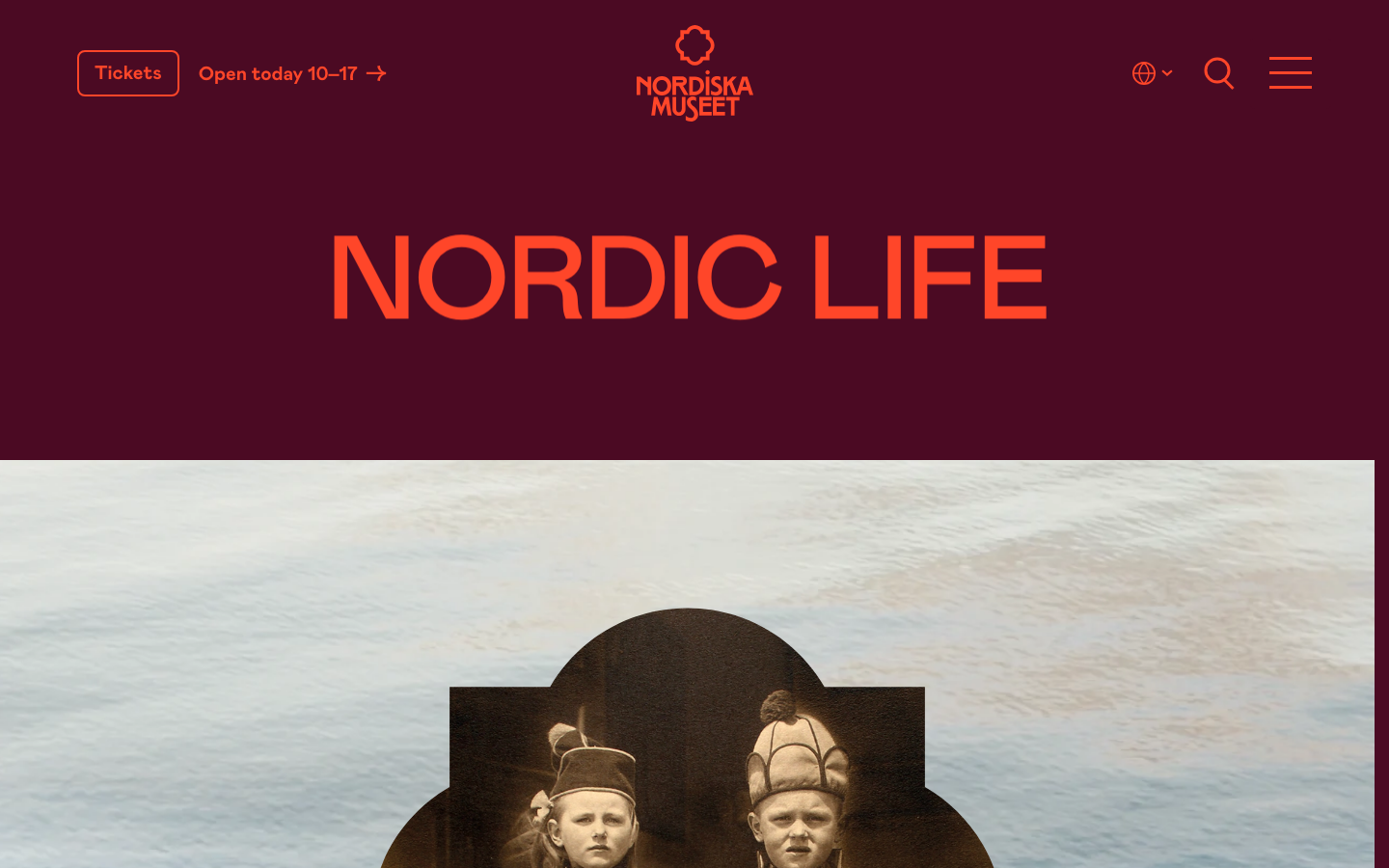 Deep burgundy background creates a high-contrast stage for bold, orange sans-serif typography. The layout transitions from a flat color block to a large-scale photographic element. · museum exhibition page, bold typography hero, burgundy and orange palette, culture website design, editorial layout