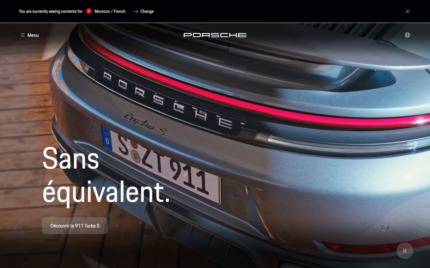 The hero image dominates the viewport, showcasing the car's rear design with a striking, almost clinical focus. The typography is clean and impactful, emphasizing the brand name and a key tagline. The overall feel is precise and sophisticated. · luxury car, sports car, porsche design, automotive hero, minimalist car, dark car, futuristic design, high contrast, silver car